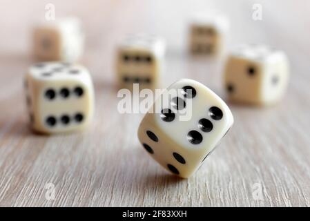 Rolling dice on a wooden desk. Stock Photo