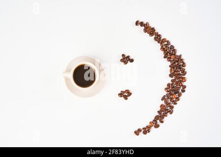 A cup of coffee and smiley emoticon made out of roasted beans Stock Photo