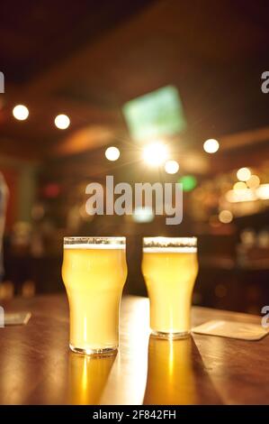 Two glasses full of fresh foamy beer on counter Stock Photo