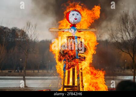 Burning Effigies Straw Maslenitsa In Fire On Traditional National Holiday Dedicated To Approach Of Spring - Slavic Celebration Shrovetide. Stock Photo