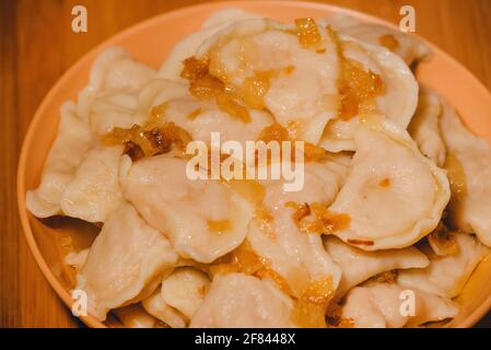 Dumplings in bowl with fried onions. Dumplings, filled with mashed potato served with fried onion Stock Photo