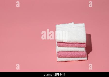 Stack of clean soft towels on pink empty space background.Towels stack,female hygiene.Spa concept Stock Photo