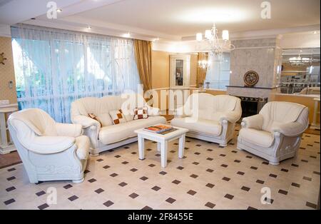 chic white leather soft furniture in a light interior. Stock Photo