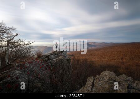 A hiker taking in the views of Shenandoah National Park from Mount Marshall on a Winter morning. Stock Photo