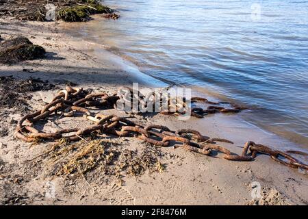 Rusty on chain on a sand beach Stock Photo