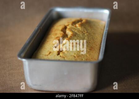 Tutti frutti cake made with whole wheat flour, served in a loaf tin. Shot on white background Stock Photo