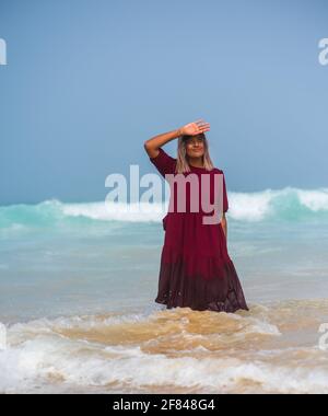 Portrait of woman standing in sea with her clothes on Stock Photo