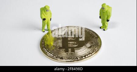 macro figures lookking on bitcoin. virtual cryptocurrency mining concept Stock Photo