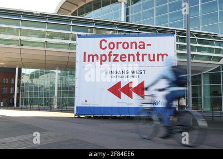 Bicyclist in front of Corona-Impfzentrum Hamburg in the exhibition halls, Hamburg, Germany Stock Photo