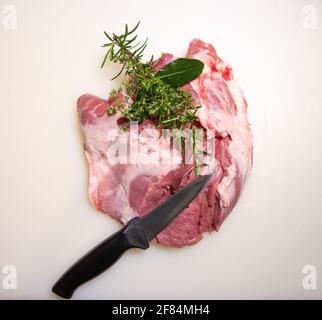Boning a shoulder of lamb leg meat on a wooden tray, white background, Top view Stock Photo