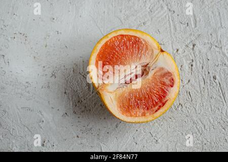 Half of fresh pink grapefruit on a gray table, top view Stock Photo