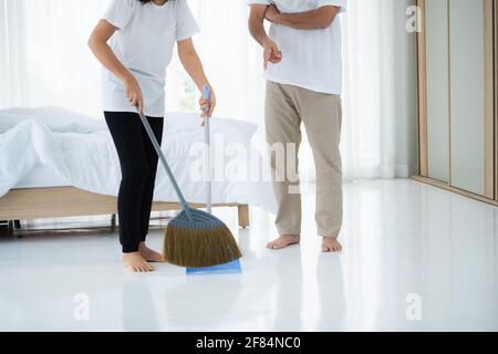 Asian senior couple cleaning bedroom floor. Retirement and healthy elderly concept. Stock Photo