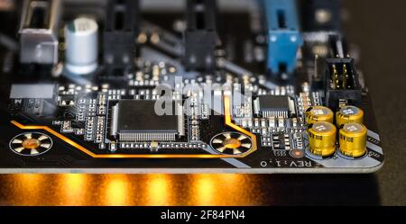 Printed circuit board on modern computer motherboard detail. Electronic components. Micro chips, capacitors, resistors. LED lights on black background. Stock Photo