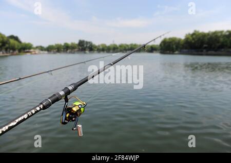 Fishing rods installed on a path by Houhai lake in northern central Beijing, China Stock Photo