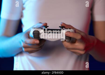 Premium Photo  Close up of gamer holding controller to play video games in  front of computer. player using joystick and playing online games on  monitor, sitting at desk. man gaming with