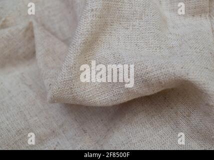 Rough linen fabric is randomly folded. Textile background Stock Photo