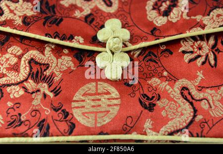 Simple floral cloth button, called a Pankou in Chinese, on a traditional Chinese female dress known as a Qipao at an exhibition in Beijing. Stock Photo