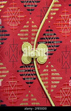 Simple floral cloth button, called a Pankou in Chinese, on a traditional Chinese female dress known as a Qipao at an exhibition in Beijing. Stock Photo