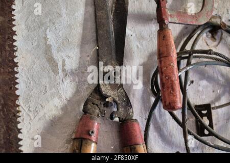 A closeup shot of old weathered instruments hanging on a wall Stock Photo