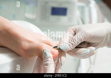 A Podiatrist doctor who takes care of a woman's toenails. Cosmetic procedures of the feet Stock Photo