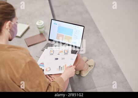 High angle view at young female student using laptop while working in modern school lounge, copy space Stock Photo