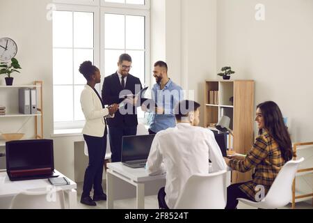 Happy creative business people working together in company office or coworking space Stock Photo
