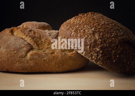 A closeup shot of two different types of bread on a wooden surface Stock Photo