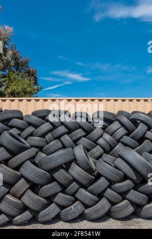 A lot of used tires stacked up outside a tire store. Stock Photo