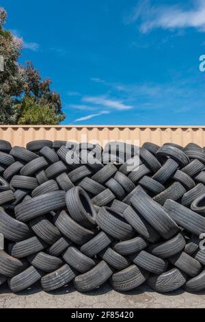 A lot of used tires stacked up outside a tire store. Stock Photo