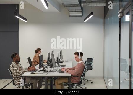 Wide angle view at group of students using computers in school library or IT lab, copy space Stock Photo