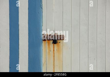Rusted lock on door with vertical stripes. Stock Photo