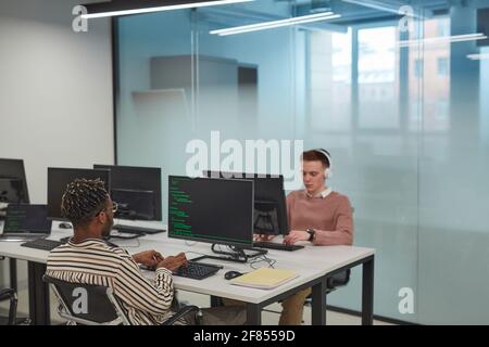 Background image of IT programmers or students using computers in office interior with glass wall, copy space Stock Photo