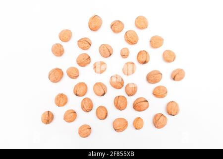 Heap of whole walnuts in the shell isolated on white background. Stock Photo