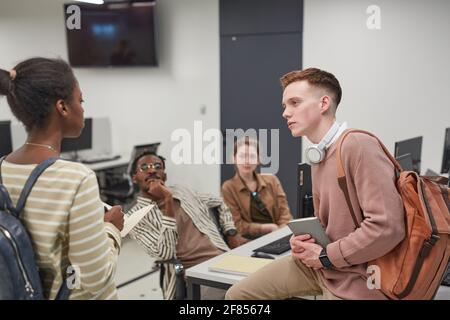 Diverse group of young people collaborating on project while working together in office or school IT lab Stock Photo