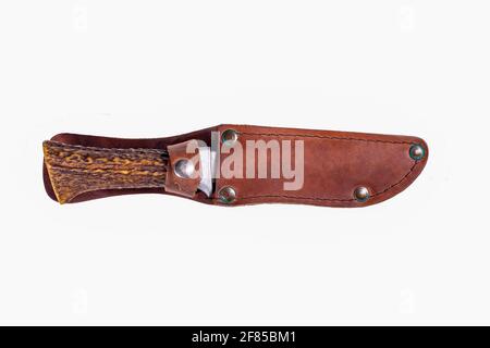 A hunting knife with a leather scabbard and a deer horn handle. Accessories for hunters hunting deer. Isolated background. Stock Photo