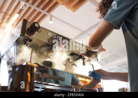 Low angle view at steaming coffee machine in cafe or coffee shop with unrecognizable barista making fresh coffee, copy space Stock Photo