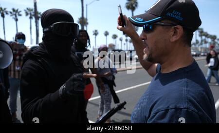 Huntington Beach, CA, USA. 11th Apr, 2021.  A man is confronted by a counter-protester in black bloc clothing. Multiple counter protesters showed up to Huntington Beach Pier on Sunday morning after "White Lives Matter Rally" fliers were circulated online. Credit: Young G. Kim/Ģ����ý Live News Stock Photo