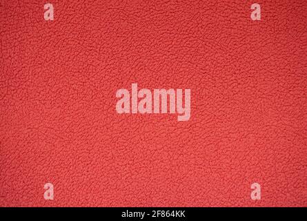 Fragment of genuine leather with fine wrinkles, artificially dyed bright red. Background, pattern, texture. Stock Photo