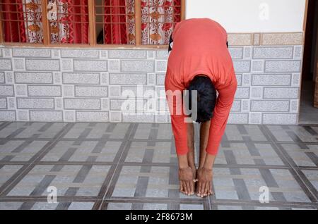 Young Asian man doing yoga for mental health awareness in his home. Stock Photo