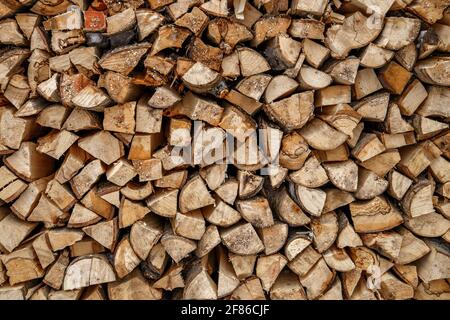 Split logs are stacked in smooth pile of firewood. Stock Photo