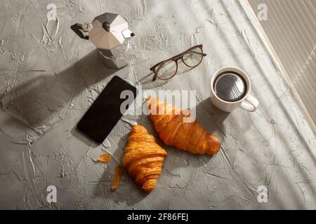 Breakfast with croissant and coffee and moka pot. Morning meal and breakfast concept. Stock Photo