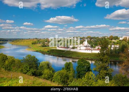 View on ancient white-stone Convent of the Dormition built in 16 century on Volga River bank with reflection in water. Staritsa, Tverskoy region, Russ Stock Photo