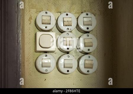 Closeup of nine old light switches in a derelict house Stock Photo