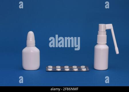 White bottles of throat spray and nasal spray, tablets in a blister pack.  Stock Photo