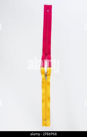 half open pink and yellow zipper. Selective Focus. isolated White Background. Top view Stock Photo