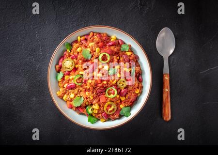 Chili con carne, a deep plate with a spoon, shot from above Stock Photo