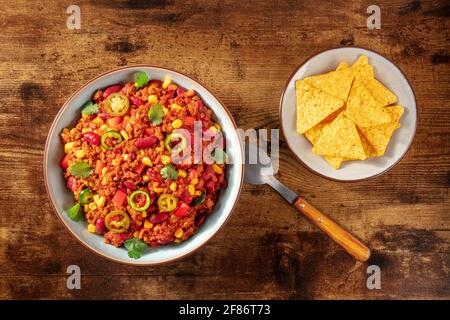Chilli con carne with nachos on a dark rustic wooden background Stock Photo