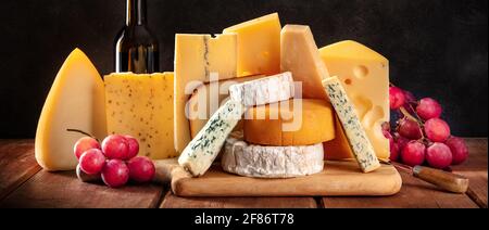 Cheese panorama with grapes and a bottle of wine Stock Photo