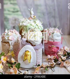 Easter composition with orthodox sweet breads or kulich decorated with white sugar icing and mastic flowers, light background. Traditional Orthodox ca Stock Photo