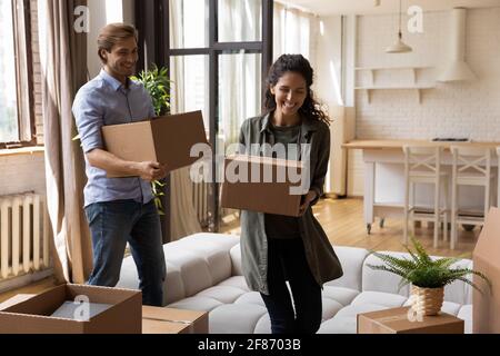 Overjoyed family carrying cardboard boxes, relocating to new apartment Stock Photo